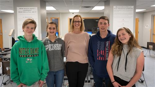 Jenny Stearns standing in her classroom with students  